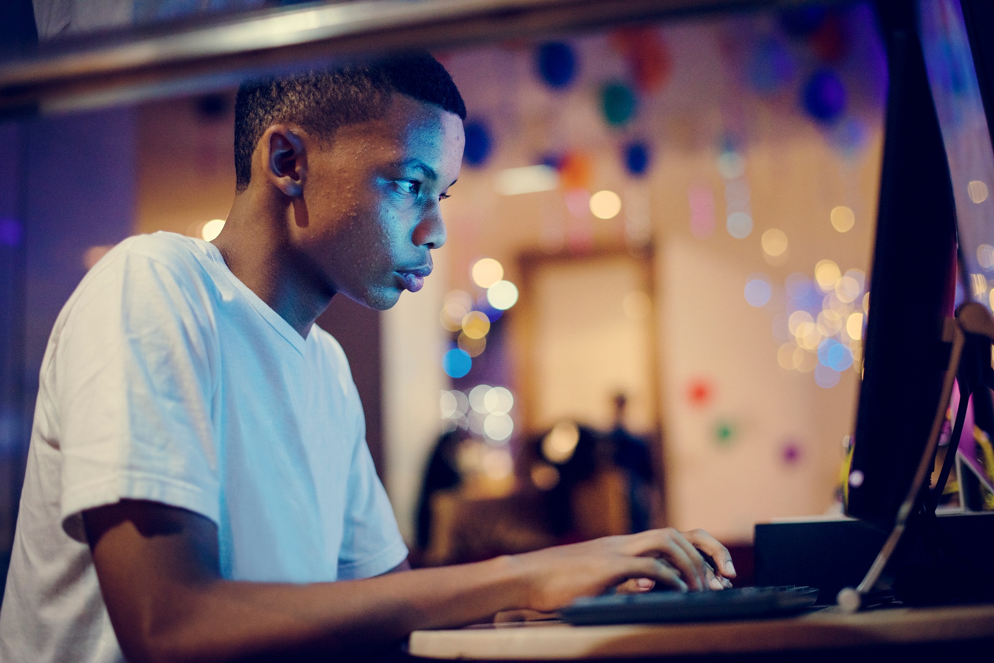 African american boy using a computer at night